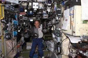 Astronauta Jeffrey N. Williams na pokładzie Międzynarodowej Stacji Kosmicznej w otoczeniu sprzętu fotograficznego. / Źródło: NASA